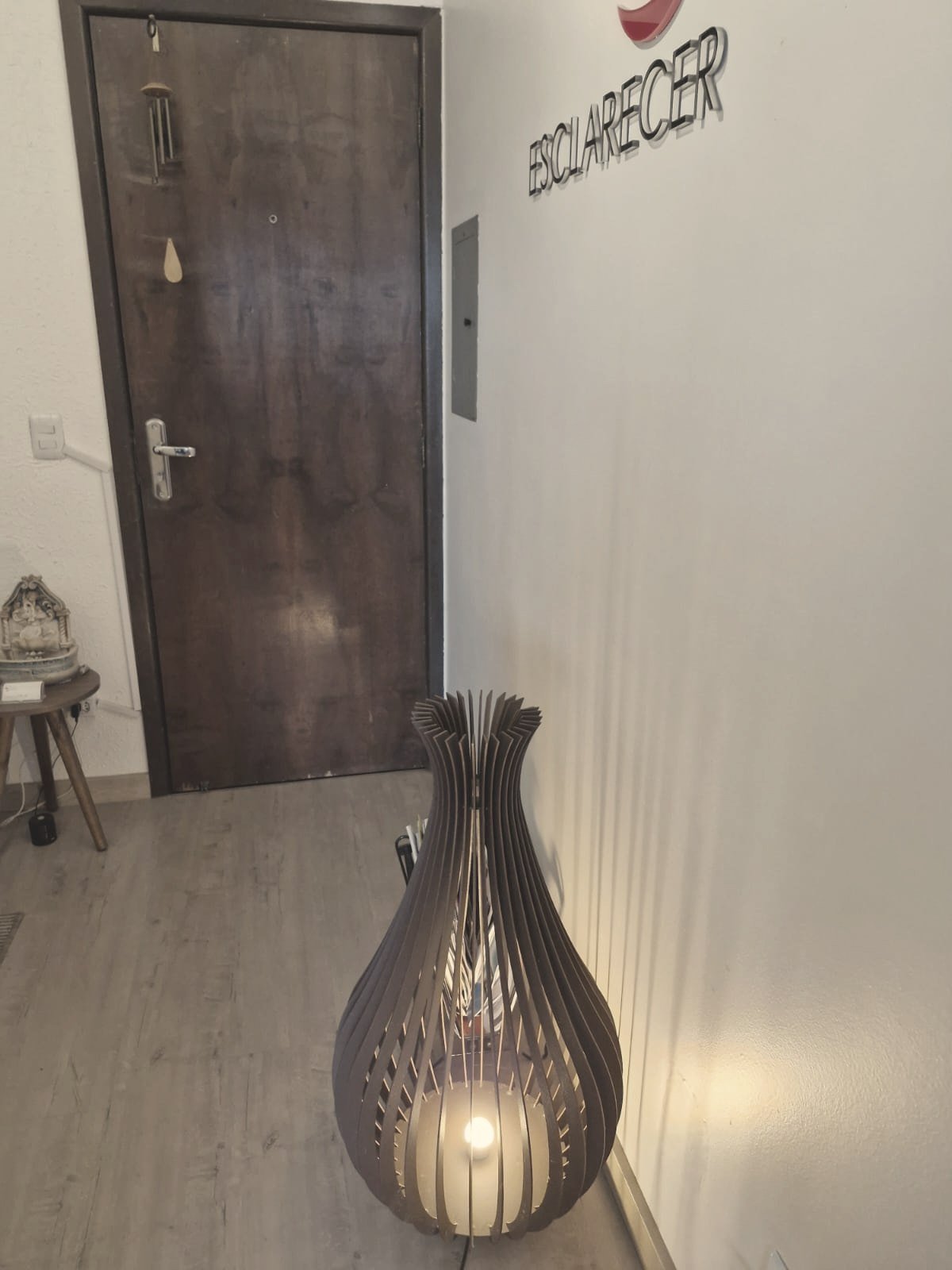 Corredor de entrada da Clínica Esclarecer com luminária artesanal de madeira