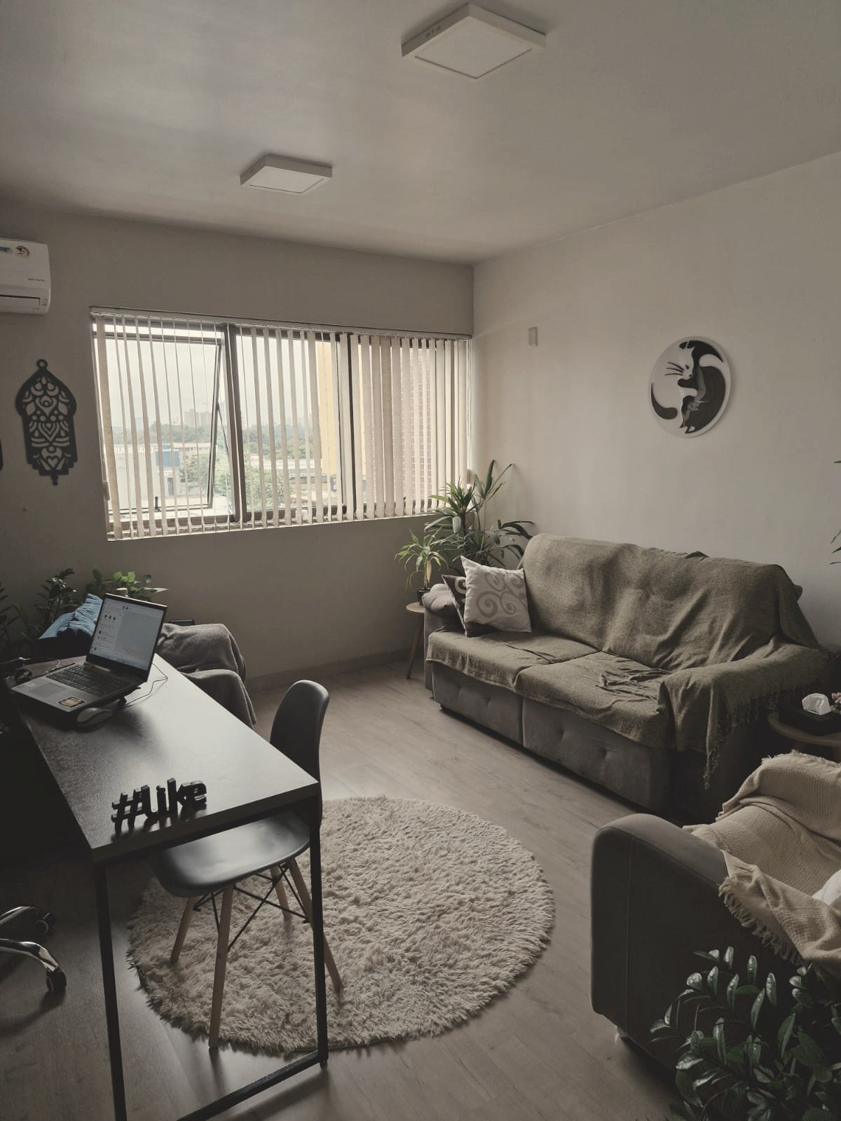 Vista geral da sala de atendimento com sofá, mesa e iluminação natural